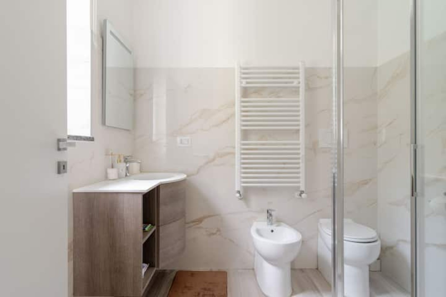 Bagno moderno con doccia, lavabo, bidet e finestra