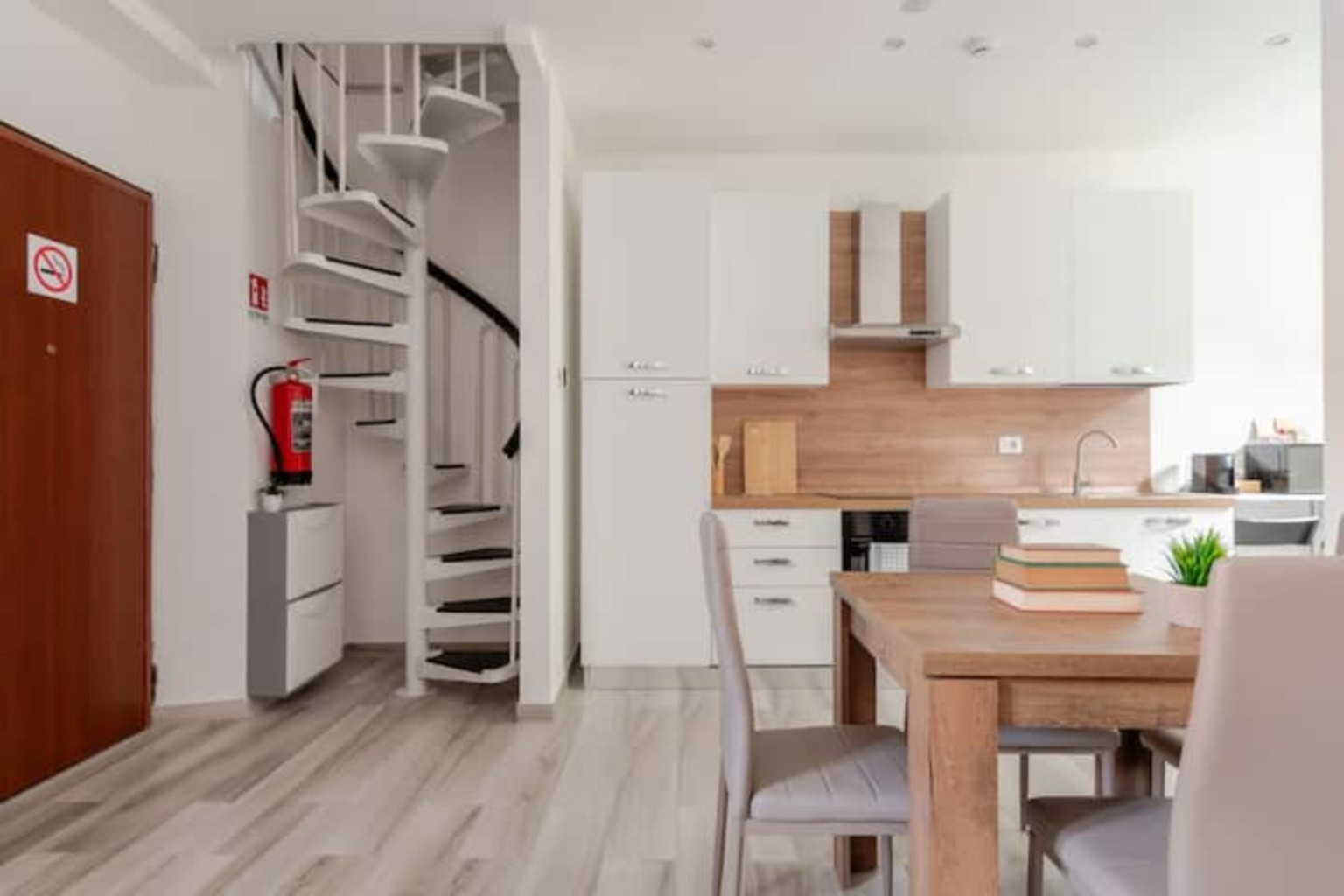 Zona pranzo e cucina con scala a chiocciola