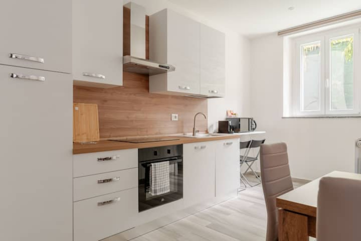 Cucina bianca attrezzata con piano in legno